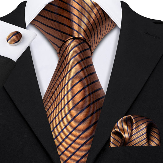 This picture is a man's black suit and white dress shirt wearing a premium silk tie set in copper with diagonal navy blue lines, including a matching pocket square and cufflinks. Sophisticated and versatile for any occasion. crafted for timeless elegance.