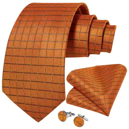 Orange copper grid pattern silk tie set with matching pocket square and cufflinks displayed together on a white background.”