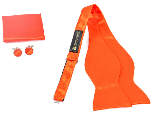 Self-tie orange silk bow tie set for men, includes adjustable bow tie, 8.5-inch matching pocket square, and cufflinks in a gift box. Elegant accessory for formal events or gift-giving.